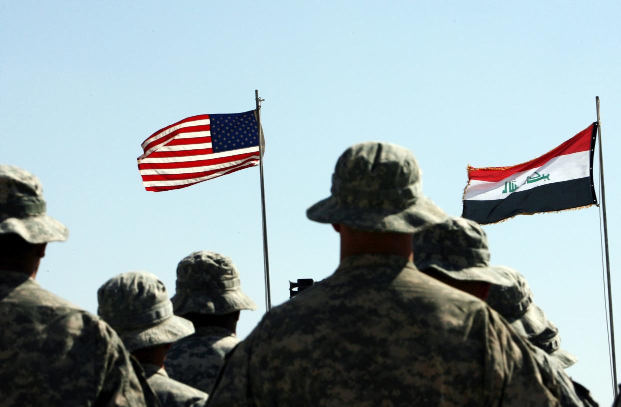 A picture taken on May 15, 2011 shows U.S. troops standing to attention in front of U.S. and Iraqi flags during a handover ceremony near the northern Iraqi town of Hawija. President Barack Obama announced on October 21, 2011 that he would withdraw all U.S. forces from Iraq by the end of the year.