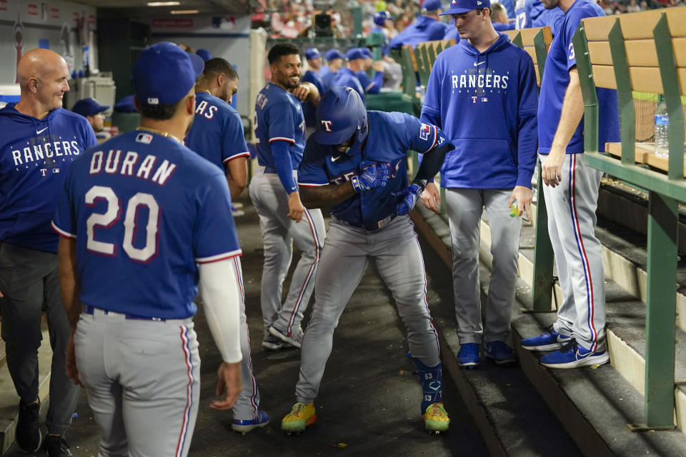 Texas Rangers' Adolis Garcia, center, dances in the dugout as he celebrates his home run during the third inning of a baseball game against the Los Angeles Angels, Wednesday, Sept. 27, 2023, in Anaheim, Calif. (AP Photo/Jae C. Hong)