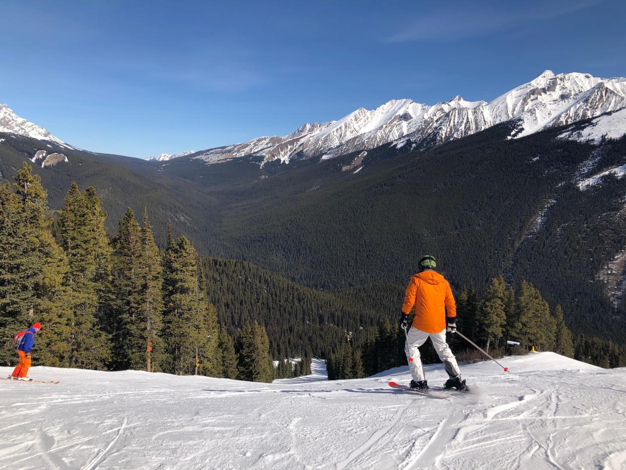 banff canada man in orange jacket skiing