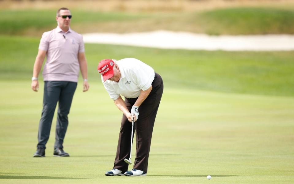 Donald Trump lines up a putt - GETTY IMAGES
