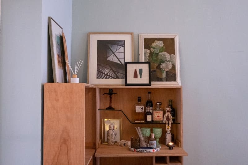 Decorative items on wooden liquor shelf.