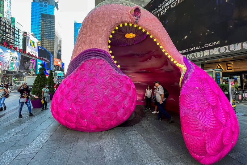 People visit a Fountain for Survivors, an immersive, 18-foot tall fountain covered in a mosaic of over 365,000 acrylic nails in Times Square in the Manhattan borough of New York, New York