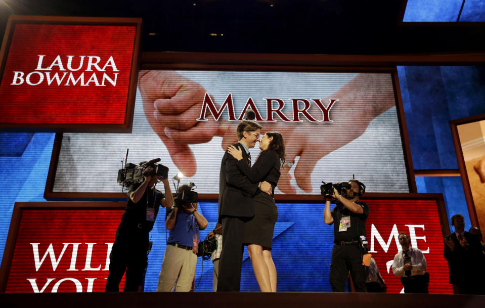 Bradley Thompson, production manager for the Republican National Convention, left, proposes to his girlfriend Laura Bowman, a production coordinator, on the stage of the convention hall, Wednesday, Aug. 29, 2012, in Tampa, Fla. (AP Photo/David Goldman)