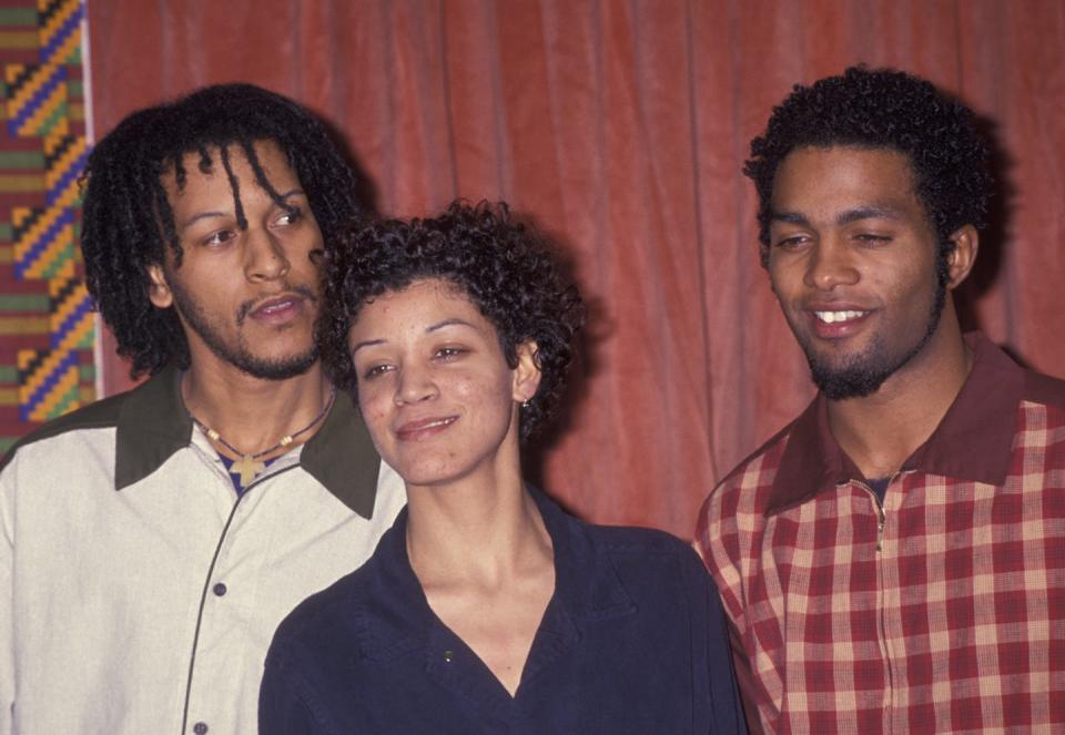 Three hip-hop artists stand together posing for a photo.