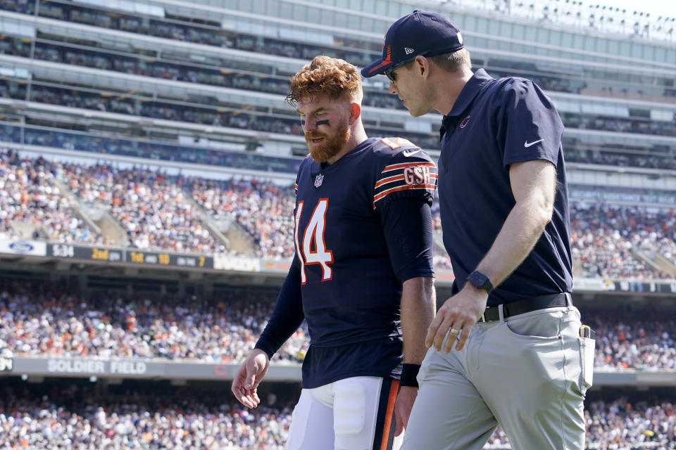 Chicago Bears quarterback Andy Dalton walks to the locker room with an unidentified trainer during the first half of an NFL football game against the Cincinnati Bengals Sunday, Sept. 19, 2021, in Chicago. (AP Photo/Nam Y. Huh)