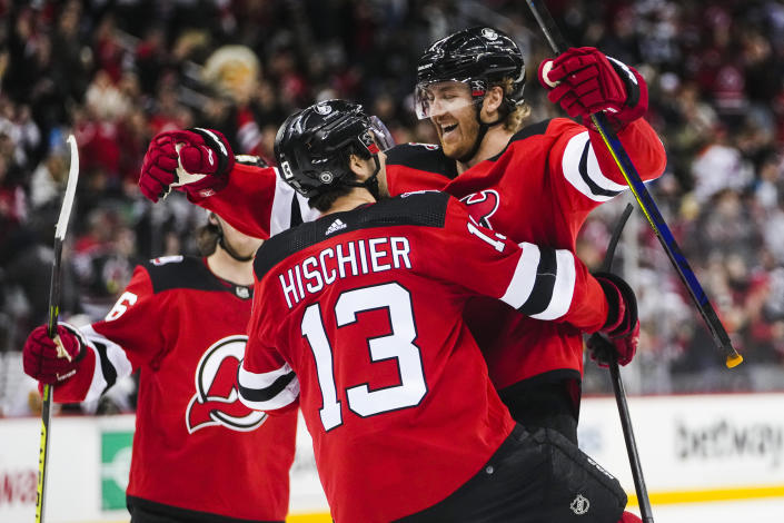 New Jersey Devils' Dougie Hamilton, right, celebrates with teammate Nico Hischier, center after scoring the game-winning goal during the overtime period of an NHL hockey game, Sunday, Jan. 22, 2023, in Newark, N.J. The Devils won 2-1. (AP Photo/Frank Franklin II)