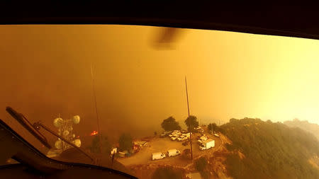 Helicopter pilots look for a landing spot during a rescue made on the fly during the Woolsey Fire in Malibu, California, in this November 9, 2018 still image taken from helmet camera footage by LAFD David Nordquist. LAFD/David Nordquist/Social Media/via REUTERS