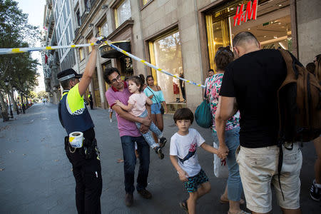 A police officer helps evacuate people after a van crashed into pedestrians near the Las Ramblas avenue in central Barcelona, Spain August 17, 2017. Ana Jimenez/La Vanguardia/via REUTERS ATTENTION EDITORS - THIS IMAGE WAS PROVIDED BY A THIRD PARTY. MANDATORY CREDIT. NO RESALES. NO ARCHIVE. SPAIN OUT.