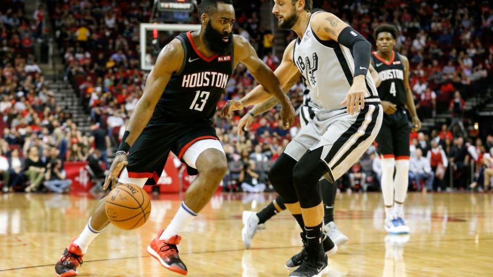 james harden dribbling a basketball in front of a defender during an nba game