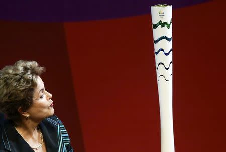 Brazil's President Dilma Rousseff looks at an Olympic Torch model during a ceremony where the Rio Organizing Committee presented the torch and relay route for the Rio 2016 Games in Brasilia, Brazil, July 3, 2015. REUTERS/Wenderson Araujo