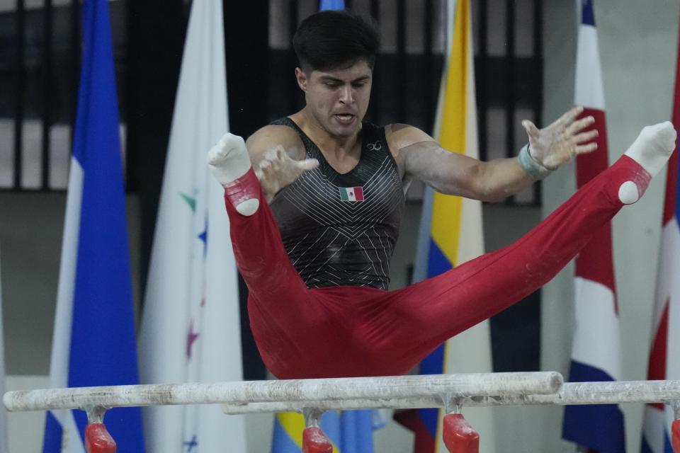 El mexicano Isaac Núñez compite en la final de barras paralelas de los Juegos Centroamericanos y del Caribe en San Salvador, el miércoles 28 de junio de 2023 (AP Foto/Arnulfo Franco)