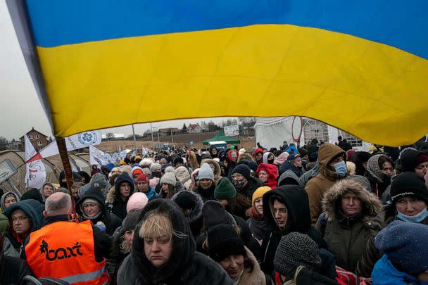 PHOTO: FILE - A Ukrainian volunteer holds a Ukrainian flag and directs hundreds of refugees after fleeing from the Ukraine and arriving at the border crossing in Medyka, Poland, March 7, 2022. (Visar Kryeziu/AP, FILE)