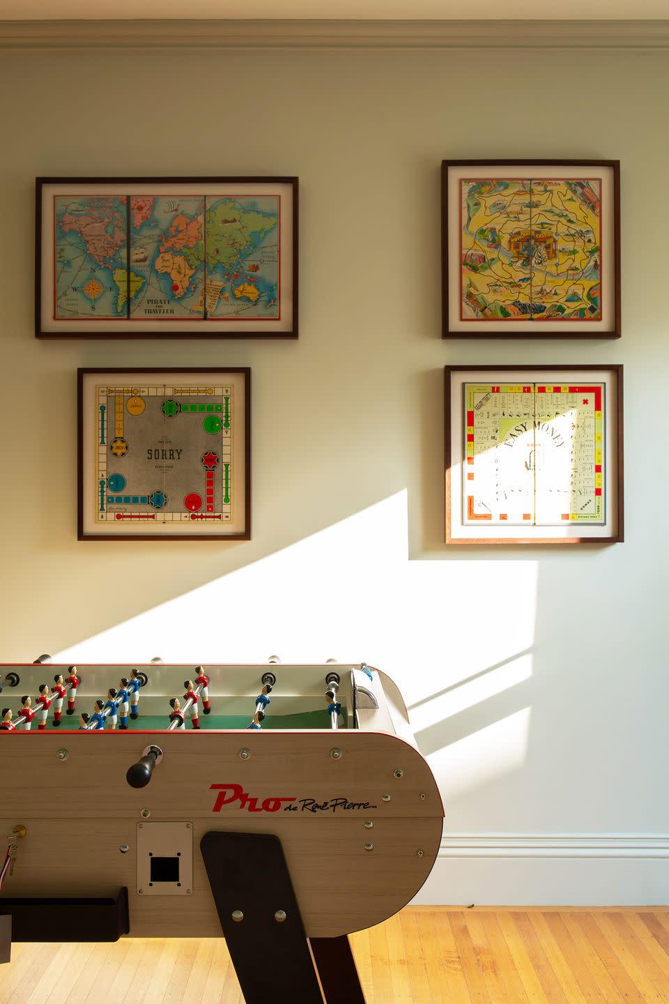 <p>Instead of tossing old board games, frame them! It's the perfect way to spruce up blank walls in a fun-centric space, like this one by<a href="https://www.jaejoodesigns.com/" rel="nofollow noopener" target="_blank" data-ylk="slk:Jae Joo;elm:context_link;itc:0;sec:content-canvas" class="link "> Jae Joo</a>. Plus, it proves that you don't have to even have an entire room to designate to a foosball table—just use an empty hallway or landing. </p>