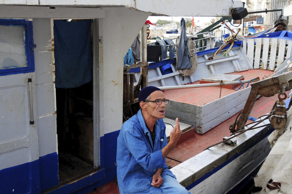 Fisherman Mohamed Taoueb, 58, talks to The Associated Press on the port of Bizerte, Tunisia, Wednesday, Sept. 23, 2020. The number of Tunisians migrating clandestinely to Italy has risen to levels not seen since the 2011 Arab Spring uprising. That's causing tensions in Italy's south, where more than 2,200 migrants are quarantining on ferries anchored offshore. (AP Photo/Hassene Dridi)