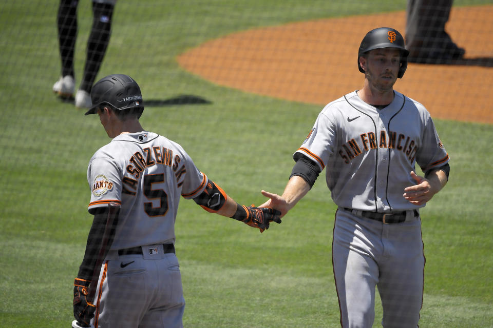 San Francisco Giants' Austin Slater, right, is congratulated by Mike Yastrzemski after scoring on a single by Darin Ruf during the first inning of a baseball game Saturday, July 25, 2020, in Los Angeles. (AP Photo/Mark J. Terrill)