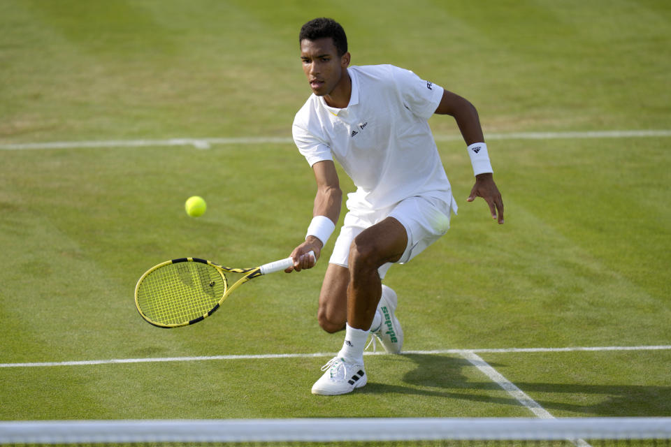 Canada's Felix Auger-Aliassime returns the ball to Maxime Cressy of the US during their singles tennis match on day two of the Wimbledon tennis championships in London, Tuesday, June 28, 2022. (AP Photo/Kirsty Wigglesworth)