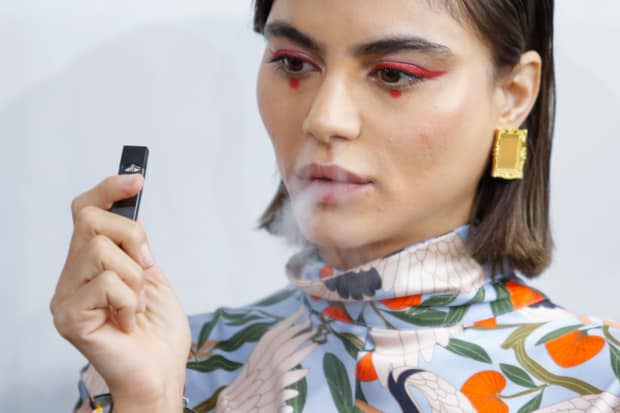 A model and her Juul at Snow Xue Gao Spring 2018 show during New York Fashion Week. Photo: Eduardo Munoz Alvarez/AFP/Getty Images