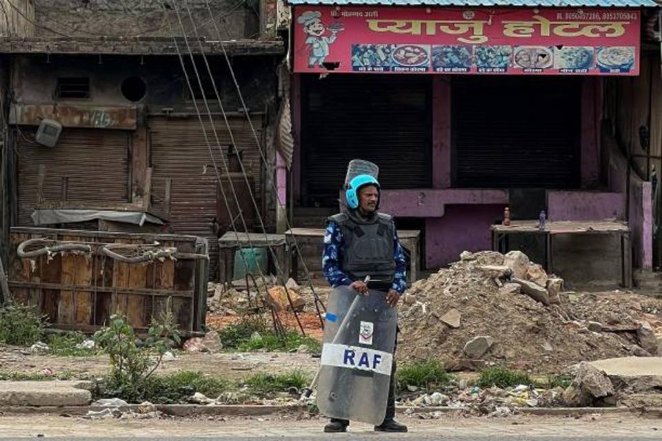 A Rapid Action Force (RAF) personnel stands beside closed shops during patrolling following communal clashes in Nuh in India’s Haryana state on 2 August 2023 (AFP via Getty Images)