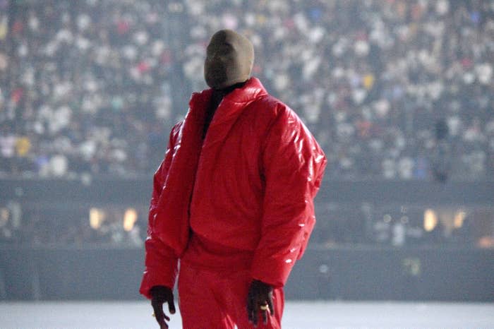 kanye west wearing a puffy red jacket and face mask