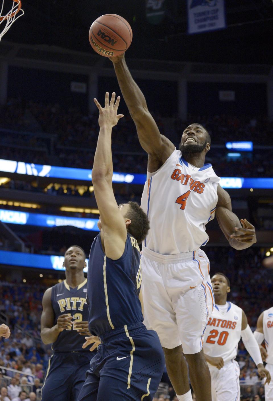 Florida center Patric Young (4) blocks a shot by Pittsburgh guard James Robinson (0) during the second half in a third-round game in the NCAA college basketball tournament Saturday, March 22, 2014, in Orlando, Fla. (AP Photo/Phelan M. Ebenhack)