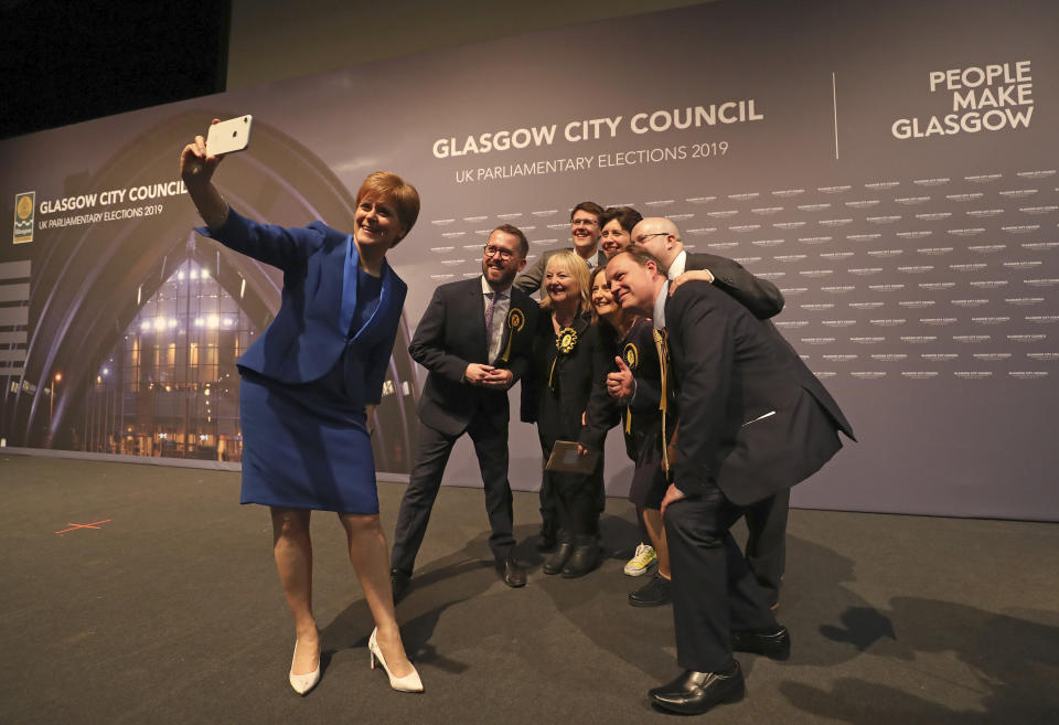 Scottish First Minister Nicola Sturgeon takes a photo with party members at the SEC Centre in Glasgow after the declaration in her constituency in the 2019 general election, Friday Dec. 13, 2019. An exit poll in Britain's election projects that Prime Minister Boris Johnson's Conservative Party likely will win a majority of seats in Parliament. That outcome would allow Johnson to fulfil his plan to take the U.K. out of the European Union next month. (AP Photo/Scott Heppell)