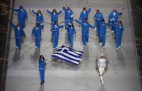 Panagiota Tsakiri of Greece holds her national flag and leads her team into the stadium during the opening ceremony of the 2014 Winter Olympics in Sochi, Russia, Friday, Feb. 7, 2014. (AP Photo/Charlie Riedel)