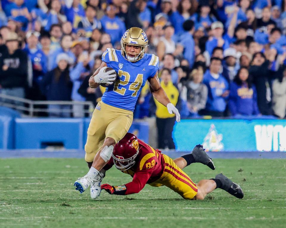 UCLA running back (and former Michigan RB) Zach Charbonnet runs away from a USC defender during the Trojans' 48-45 win on Nov. 20, 2022, at the Rose Bowl. Charbonnet rushed for 95 yards on 19 carries for UCLA.