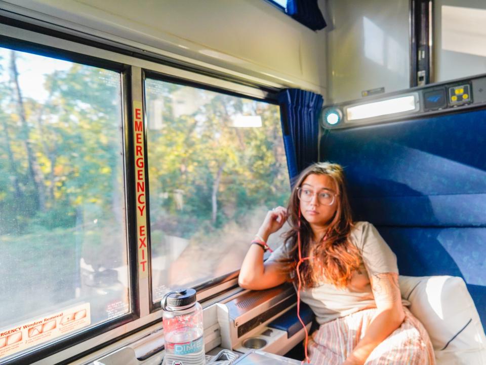 The author sits in a train seat facing the direction the train is going