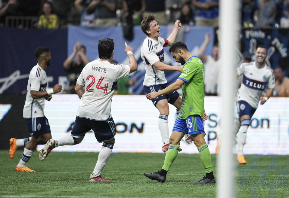 Vancouver Whitecaps' Brian White (24) and Ryan Gauld, back center, celebrate Gauld's goal as Seattle Sounders' Alex Roldan (16) walks past during the second half of an MLS soccer match in Vancouver, British Columbia on Saturday, May 20, 2023. (Darryl Dyck/The Canadian Press via AP)