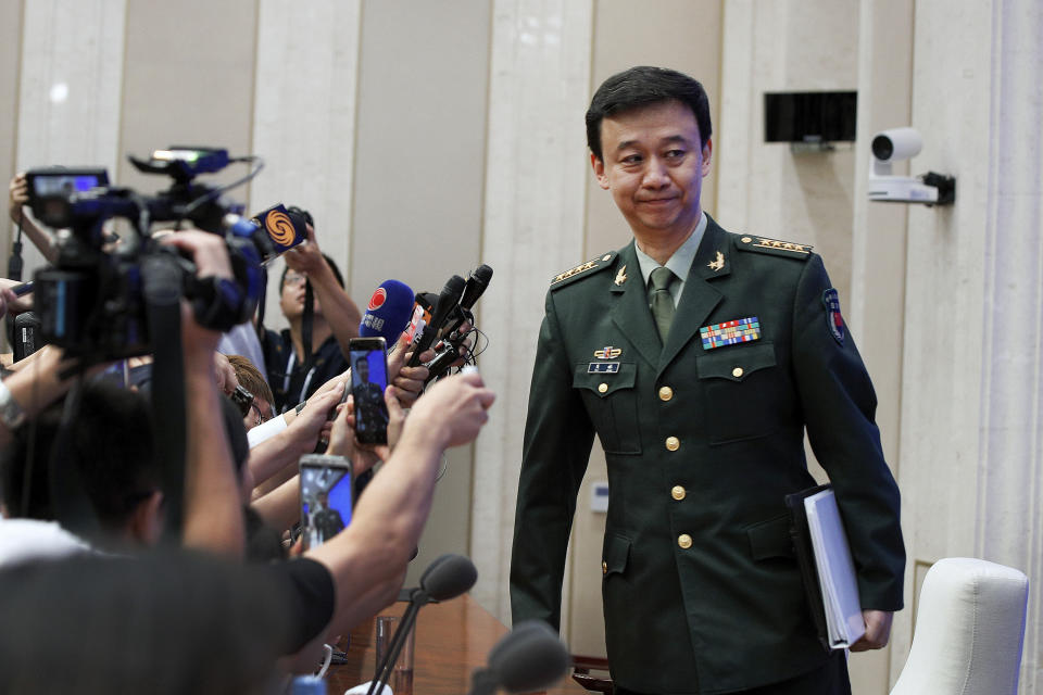China's Defense Ministry spokesman Wu Qian leaves as journalists are asking question on Hong Kong's recent protests after a press conference at the State Council Information Office in Beijing, Wednesday, July 24, 2019. China says it will not "renounce the use of force" in efforts to reunify Taiwan with the mainland and vows to take all necessary military measures to defeat "separatists." (AP Photo/Andy Wong)