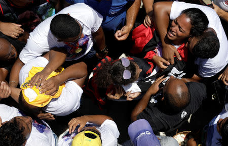 Cristiano Esmerio, (L) and Andrea Candido (Top R), parentes of Christian Esmerio react during his burial after a deadly fire at Flamengo soccer club's training center, in Rio de Janeiro, Brazil February 10, 2019. REUTERS/Ricardo Moraes