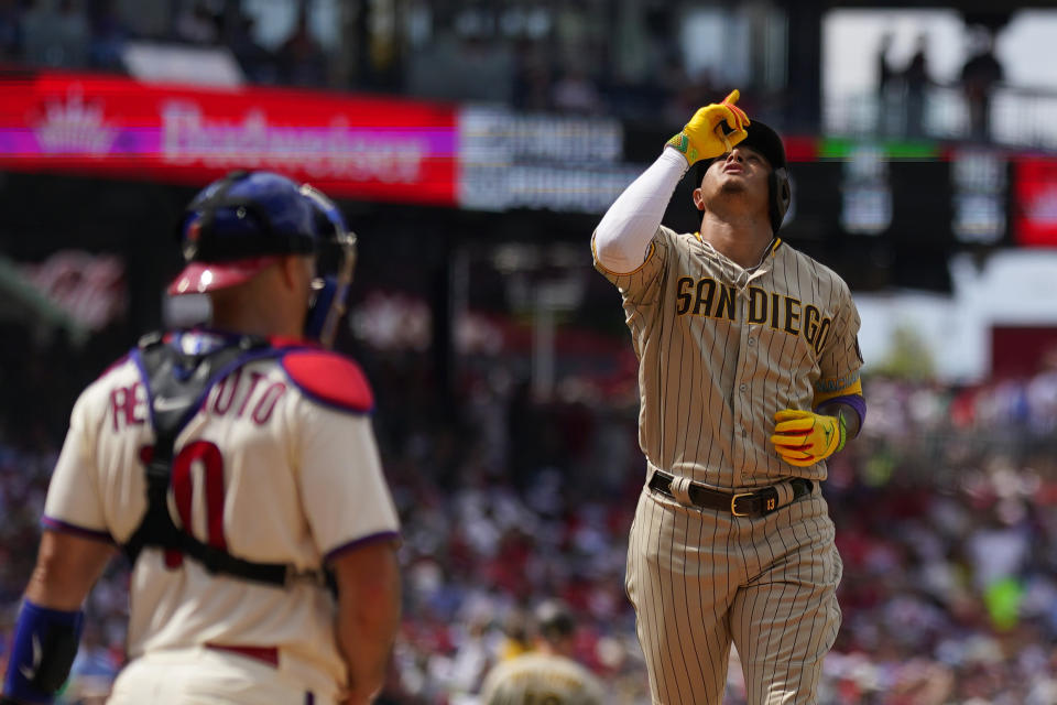 San Diego Padres' Manny Machado, right, reacts past Philadelphia Phillies catcher J.T. Realmuto after hitting a home run during the eighth inning of the first baseball game in a doubleheader, Saturday, July 15, 2023, in Philadelphia. (AP Photo/Matt Slocum)