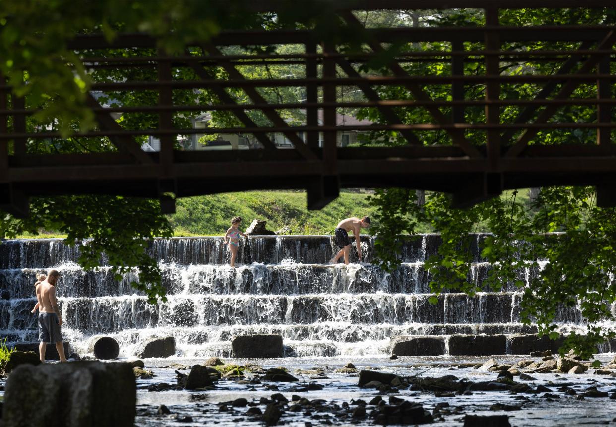 Local residents cool off at the Reservoir Park spillway in Massillon. The city is seeking community input on its new parks master plan and will hold a public meeting Tuesday to gather feedback.