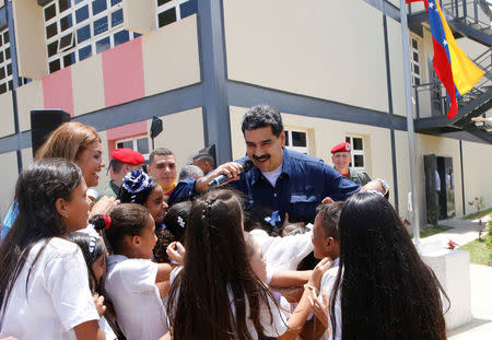 Venezuela's President Nicolas Maduro (C) greets children as he arrives to a school for an event related to the beginning of classes in Caracas, Venezuela September 18, 2017. Miraflores Palace/Handout via REUTERS