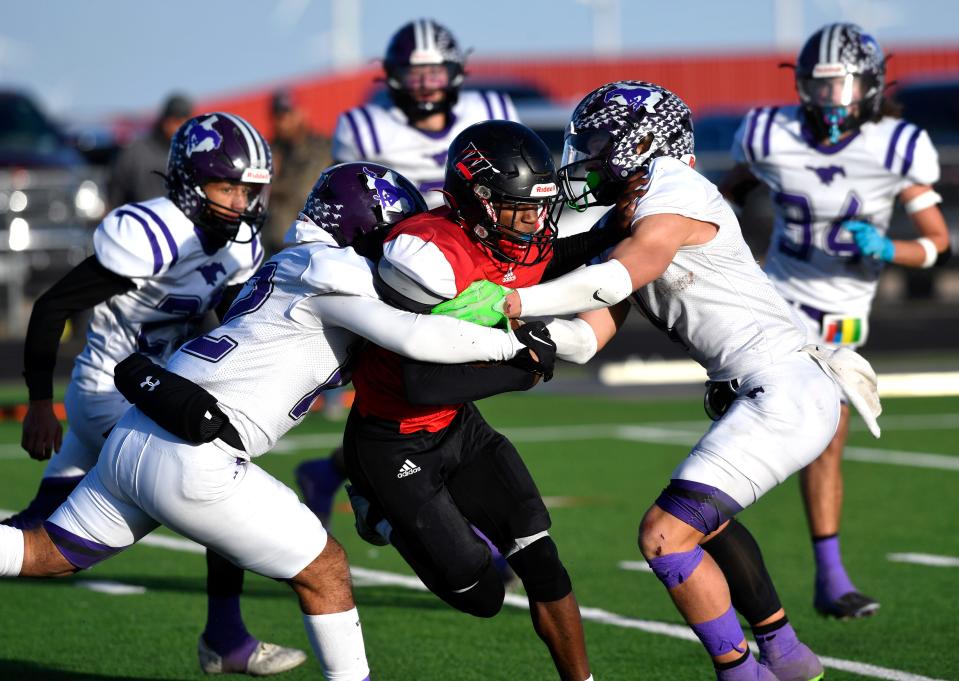 Benjamin defensive back Mario Silva (left) and linebacker Grayson Ridden stop Whitharrel wide receiver Shamadrick Weaver Saturday in Hermleigh.