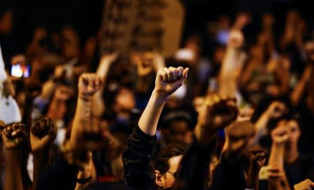 Marchers hold up fists outside the Charlotte-Mecklenburg Police Department during a protest against the police shooting of Keith Scott, in Charlotte. REUTERS/Jason Miczek