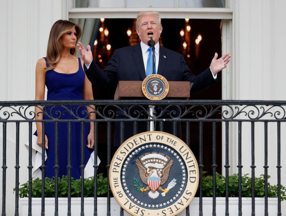 President Donald Trump, with first lady Melania Trump, speaks from the Truman Balcony at a picnic for military families on the South Lawn of the White House on July 4, 2017.