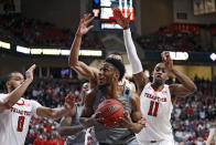 West Virginia's Pauly Paulicap (1) tries to shoot the ball around Texas Tech's Kevin McCullar (15) and Bryson Williams (11) during the first half of an NCAA college basketball game on Saturday, Jan. 22, 2022, in Lubbock, Texas. (AP Photo/Brad Tollefson)