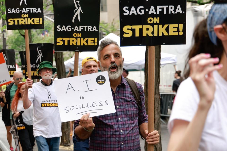 A member of SAG-AFTRA pickets in New York City on July 21 holding a sign decrying artificial intelligence. Debates about the role of AI in Hollywood are raging as the actors and writers unions are on strike.