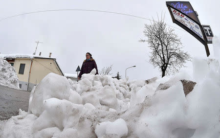 A woman walks in the town of Farindola, central Italy, following a series of earthquakes and a snow avalanche hitting a hotel in central Italy, January 20, 2017. REUTERS/Emiliano Grillotti