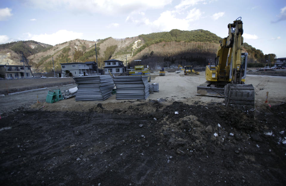 In this Monday, March 3, 2014 photo, a loading shovel scoops dirt off the land ahead of construction of a public housing complex for survivors of the March 11, 2011 tsunami, in Otsuchi, Iwate Prefecture, northeastern Japan. Iwate Prefecture plans to build a total of 6,038 public housing units for those whose homes were wiped out in the 2011 disasters. As of the end of January, less than 8 percent of those units were done, with about 60 percent of them not due for completion until 2015 at the earliest. (AP Photo/Junji Kurokawa)