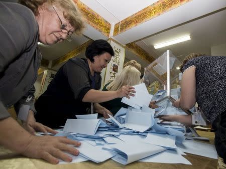 Members of a local election committee empty a ballot box to count votes after snap presidential election in Almaty, Kazakhstan, April 26, 2015. REUTERS/Shamil Zhumatov