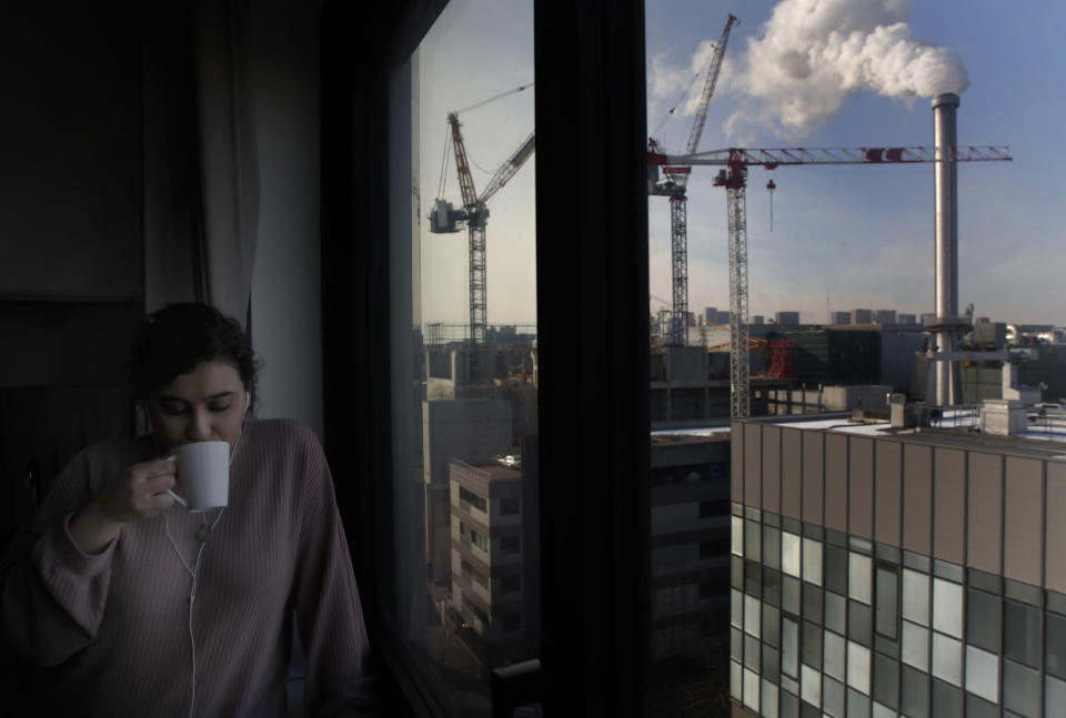 Nouhaila Fakhor from Morocco, a student of commerce, drinks a cup of tea in her student housing in Ivry sur Seine, outside Paris, Thursday, Feb. 11, 2021. A quarter of French young professionals can't find work, and many university students are standing in food lines or calling hotlines for psychological help. They are France's future, and their plight is central to the country's battle to emerge from the pandemic. (AP Photo/Christophe Ena)