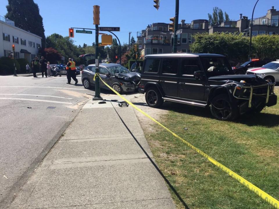 A Mercedes and a Nissan jeep are seen mounted on a curb at the intersection of Cornwall and Arbutus in Vancouver's Kitsilano neighbourhood, moments after a collision that left a five-year-old girl with serious injuries.  (Richard Campbell/@wrychrd - image credit)