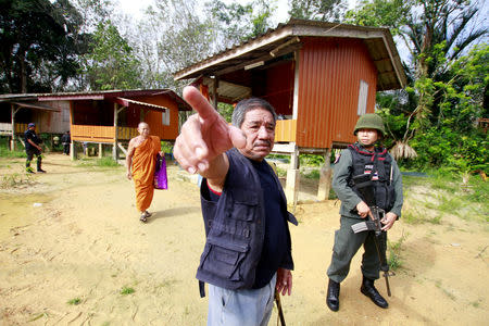 Military police officers and a buddhist monk are seen at a temple where unknown gunmen shot dead two Buddhist monks and injured two others on Friday in Su-ngai Padi district in the southern province of Narathiwat, Thailand, January 19, 2019. REUTERS/Surapan Boonthanom