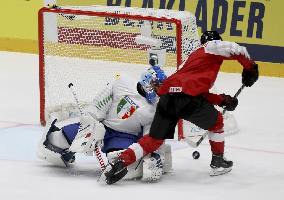 Italy's goalkeeper Andreas Bernard checks Austria's Alexander Rauchenwald, from left, during the Ice Hockey World Championships group B match between Austria and Italy at the Ondrej Nepela Arena in Bratislava, Slovakia, Monday, May 20, 2019. (AP Photo/Ronald Zak)