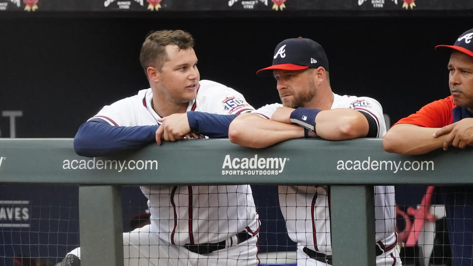 Newly acquired Braves outfielder Joc Pederson, left, and catcher Stephen Vogt talk in the dugout during a baseball game against the Tampa Bay Rays, Saturday, July 17, 2021, in Atlanta. (AP Photo/John Bazemore)