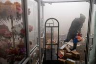 <p>A man takes flowers from a store near the Minneapolis Police Department’s Fifth Precinct building. </p>