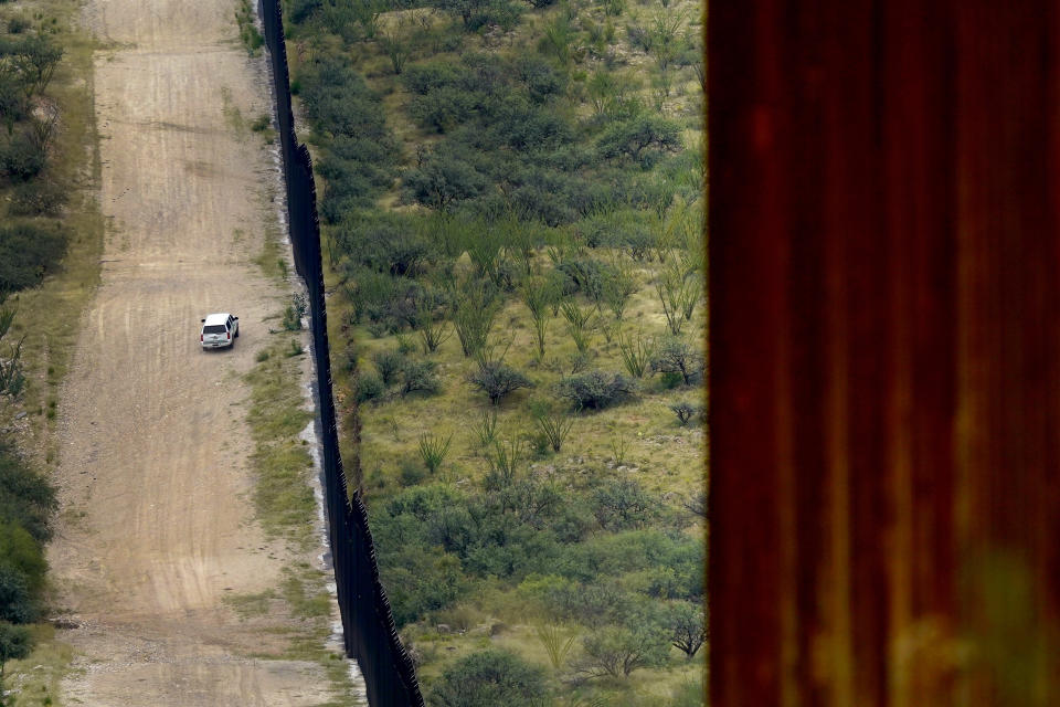 A U.S. Border Patrol agent patrols along the 30-foot high border wall, Thursday, Sept. 8, 2022, in Sasabe, Ariz. Dramatic elevation drops, mountains, uneven topography, washes and triple-digit temperatures in the summer months are common along the wall in this region at the base of the Baboquivari Mountains in the Tucson sector. This stretch is one of the deadliest along the international border. Border Patrol agents performed 3,000 rescues in the sector in the past 12 months. (AP Photo/Matt York)