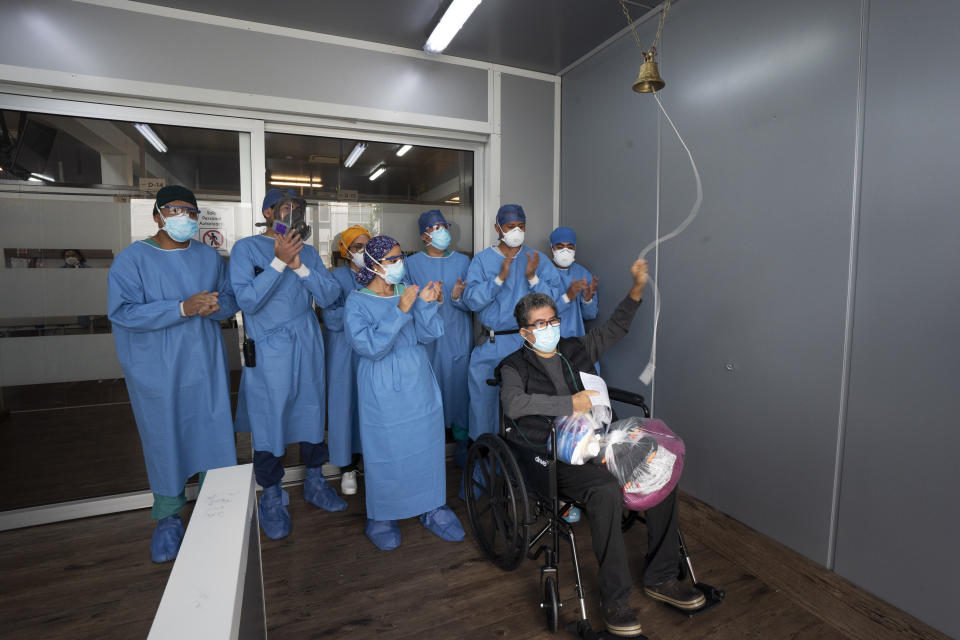 Medical staff cheer as Sergio del Rio, 56, rings the bell as he he released from the Ajusco Medio General Hospital which is designated for COVID-19 cases only, in Mexico City, Tuesday, Aug. 31, 2021. (AP Photo/Marco Ugarte)
